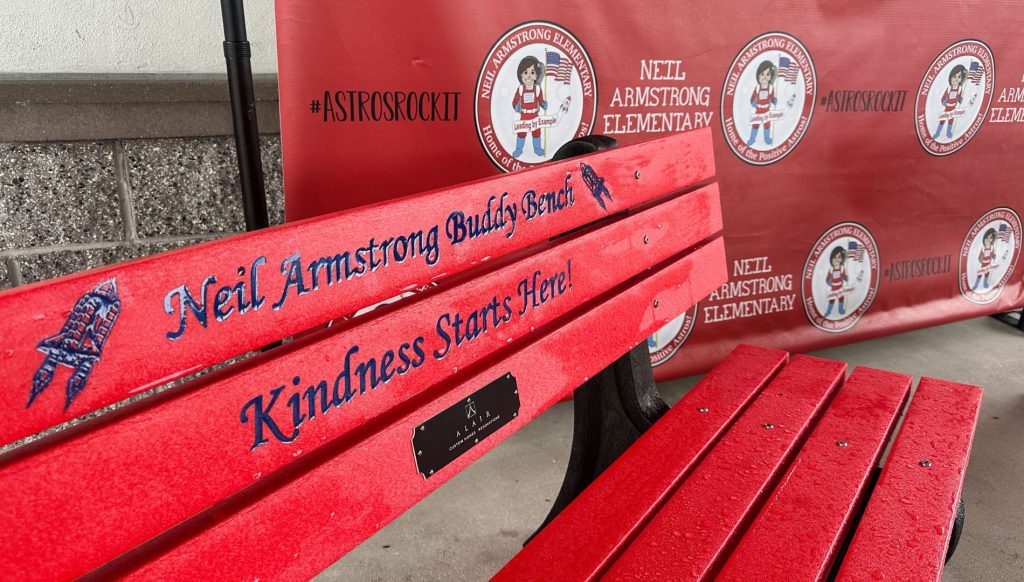 Two custom-designed 'Buddy Benches' placed on the playground at Neil Armstrong Elementary, providing a welcoming space for students to connect and build friendships during recess.