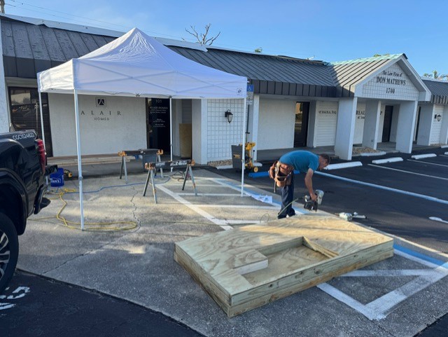 Alair Homes team working on the foundation of The Woof Lodge dog house.